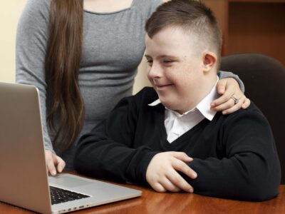 Aura Fundació discusses the importance of cognitive stimulation for people with intellectual disability. Person with Down syndrome working with a computer.