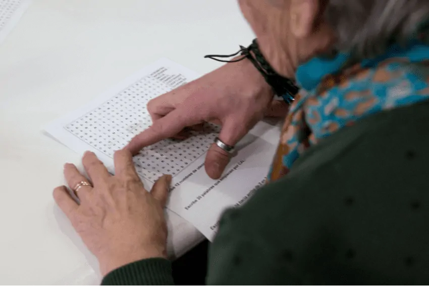 Speech therapy in Parkinson's disease. Older woman with Parkinson's working on language. Language in Parkinson's.