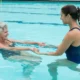 Aquatic occupational therapy, elderly woman training with weights in the pool
