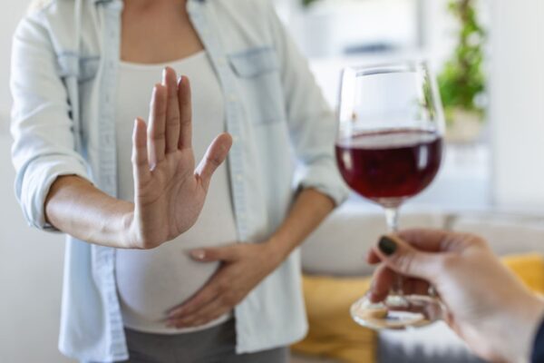 Fetal Alcohol Spectrum Disorder (FASD). Pregnant woman declining a glass of wine.