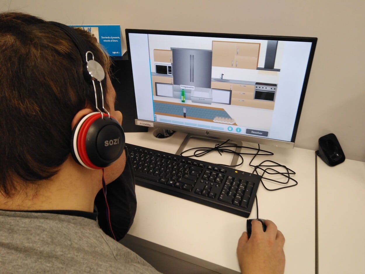 A boy with Down syndrome working with the NeuronUP activity "Straighten Up the Kitchen".