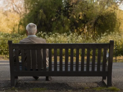 How to fight unwanted loneliness in elderly people. Old man sitting alone on a bench.