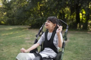 Cerebral palsy: understanding and managing a complex neurodevelopmental condition. Girl with cerebral palsy in a chair outdoors.