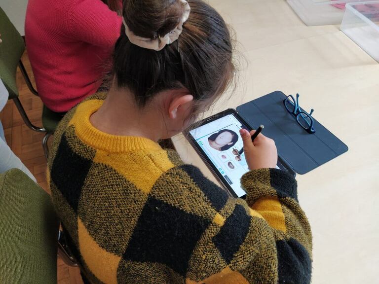 Working with people with Down syndrome by age groups. A girl using the NeuronUP activity for working on gnosis called Face Formation.