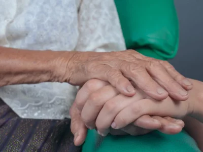 Two hands clasped. Aging of people with Down syndrome.