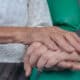 Two hands clasped. Aging of people with Down syndrome.