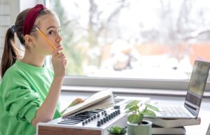 Towards a neurodidactics of musical learning. Girl thinking, doing music exercises with a piano.