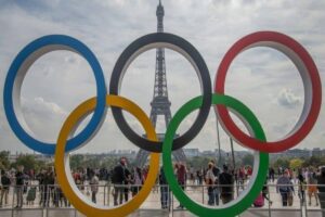 2024 Paralympic Games events and the importance of mental health. Symbolic rings of the Olympic Games and behind the Eiffel Tower.