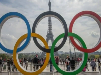 2024 Paralympic Games events and the importance of mental health. Symbolic rings of the Olympic Games and behind the Eiffel Tower.