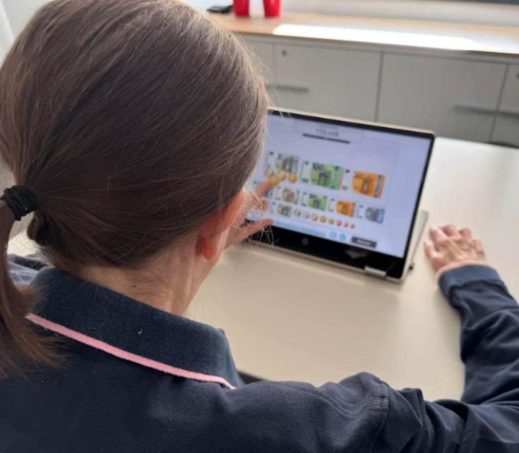 Patient in a home-care setting using NeuronUP on a tablet for motor aphasia therapy during a one-on-one session.