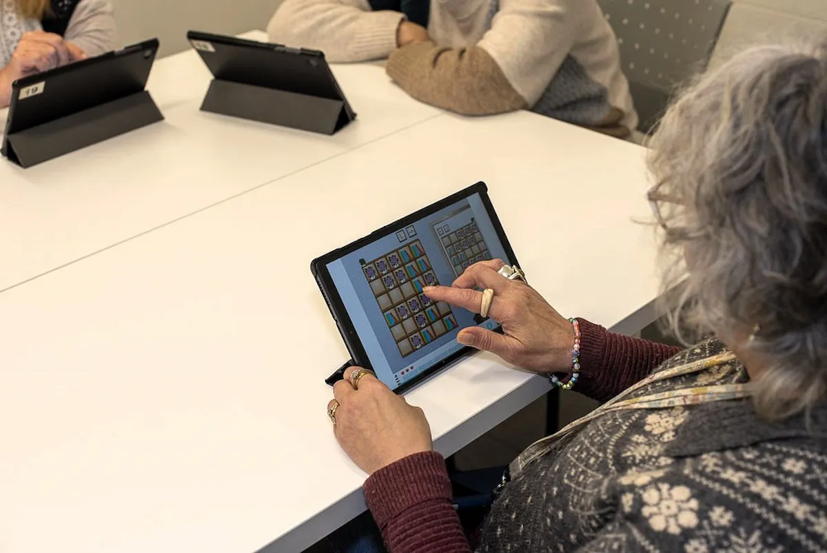 Woman using a NeuronUP activity on a tablet during a group session at Elkarkide Iturrama.