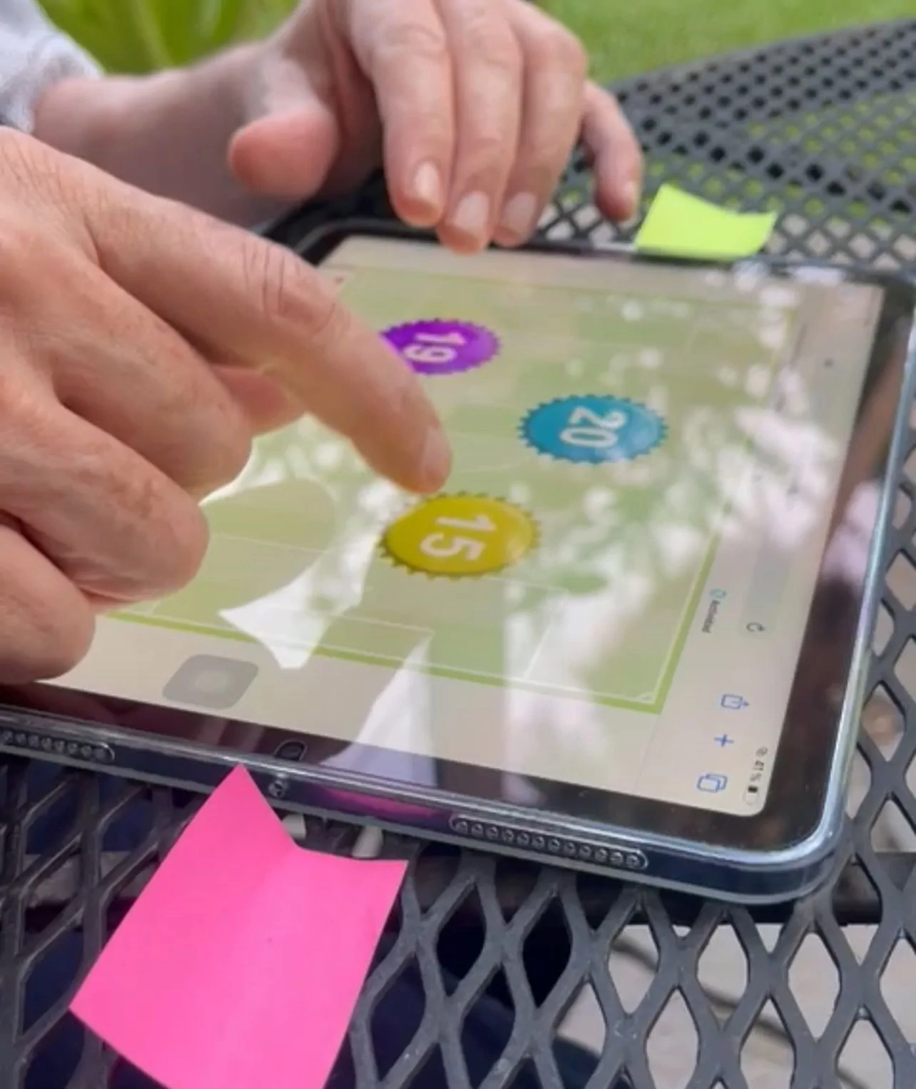 A professional at a psychoeducational center holding a tablet with NeuronUP, surrounded by sticky notes and plants.